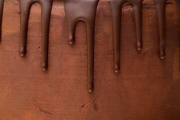 chocolate drips on the background of dark chocolate ganache