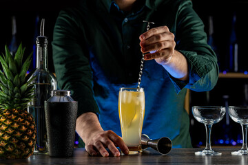 Bartender's hands serving cocktails on bar counter in a restaurant, pub. Mixed drinks. Alcoholic cooler beverage at nightclub on dark background
