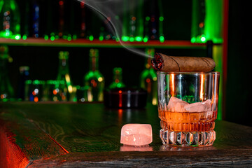 Cigar, elegant glass of brandy on the bar counter. Alcoholic drinks, cognac, whiskey, port, brandy,...