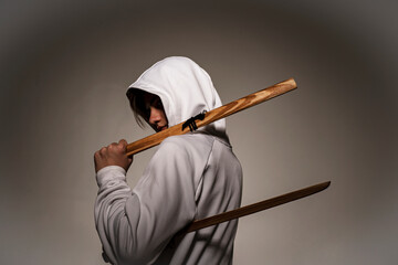 portrait of a teenager in a white hoodie with a wooden ball. Back view