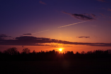 A beautiful sun rises over the treetops. Springtime scenery of Northern Europe.