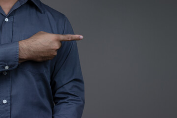 Close-up of business man's hand pointing finger at empty space for text, copy space, Businessman pointing finger on gray background.