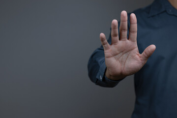 Obraz premium man showing stop gesture reject on black background with empty space for text, copy space, close up of the hand, anti concept, rejection