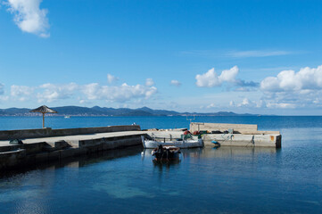 Old pier with traditional wooden fishing boats moored and prepared fishing nets, in Bibinje, Croatia