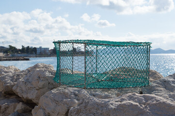 Portable traditional fishing trap for catching octopus, crabs, made of iron bars and green nylon...