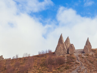 Sharp stone sculptures resembling fangs are located on the tops of mountains at the foot of the Caucasus on an autumn November day.