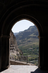 cave where the surroundings are dark but in the hole you can see the mountain.