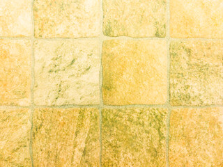 Square yellow stone tile with stone texture and scuffs. Yellow vintage background.
