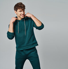 Handsome man wear of green set of track suit isolated on gray background - 490754689