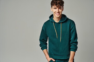 Handsome man wear green hoodie isolated on gray background