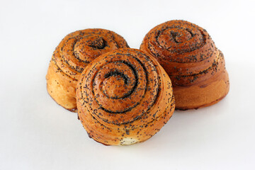 three sweet twisted buns with poppy seeds on a white background