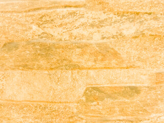 The old stone wall is yellow with damage. Yellow vintage background with brick texture.
