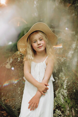Ukrainian 7 year old girl with white hair like an angel walking in the woods on the rocks.