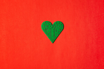 Circuit board in the shape of heart on red background.