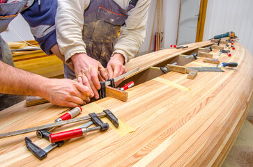 Carpenters making wooden boat in carpenter workshop.