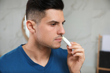 Man applying hygienic lip balm in bathroom