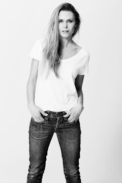 Monochrome chic. Croppy studio portrait of a an attractive young woman standing with her hands in her pockets.