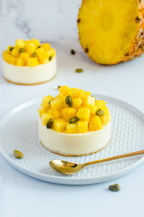 mini cheesecakes with pineapple and pistachios on a light background