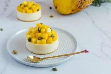 mini cheesecakes with pineapple and pistachios on a light background