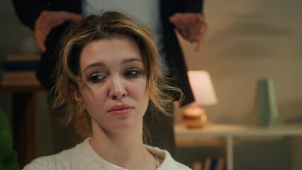 Young sad woman portrait. Emotional man arguing in living room, feeling anger and stress, bad mood. Scandals, family problems, relationship crisis. Young couple quarreling. 