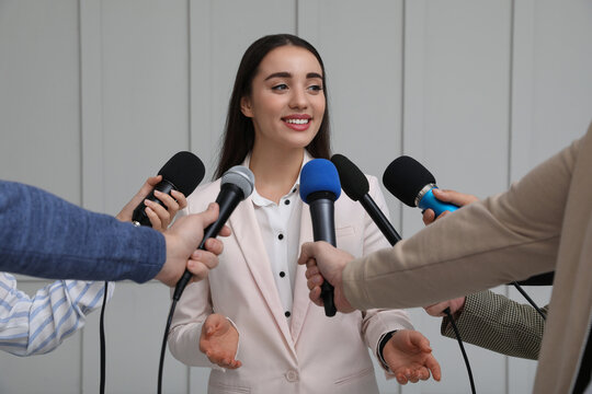 Happy business woman giving interview to journalists at official event