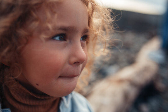 Mischievous Blonde Curly Child Girl With Green Eyes