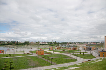 Fototapeta premium Views of the city of Syzran, Samara region, Russia. Summer cloudy weather. City park and road bridge.