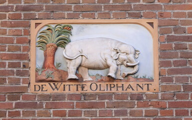 Historic Sculpted Stone Tablet with a White Elephant and a Palm Tree on a Brick Wall in Amsterdam,...