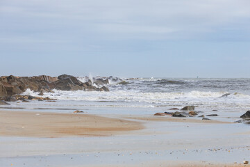 Fototapeta na wymiar Rocks on the beach, ocean, waves, blue sky 
