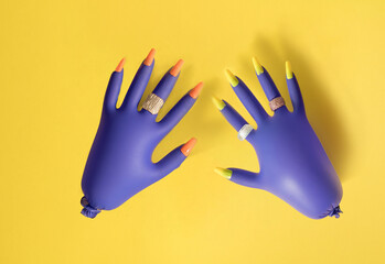 Blue surgical gloves with jewelry, and long colored nails against a yellow background. Flat lay. Minimal pandemic concept.