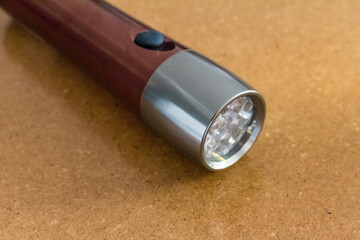 Shiny Modern LED Flashlight on Wood Table