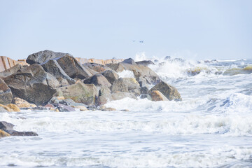 Rocks on the beach, breakwater, ocean, waves, blue sky 