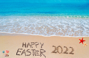 happy easter 2022 written on a tropical beach