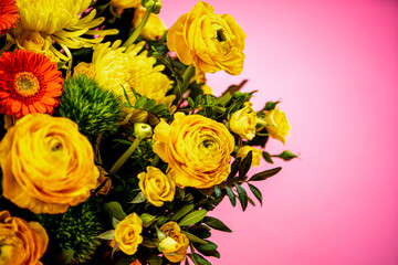 Bouquet of yellow-orange flowers close-up on a pink background