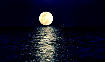 super moon rising over Atlantic Ocean with reflection on water