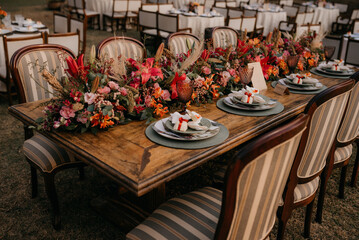 table decorated with flower paths with decorated porcelain plates, with woody color palette beautiful wedding dinner table
