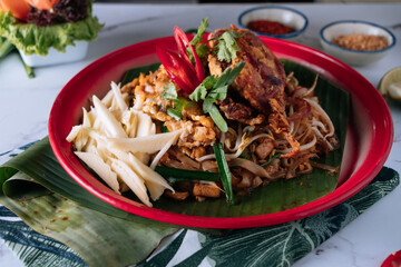 Pad Thai Soft Shell Crab noodle with red chilli in a dish isolated on mat top view on grey marble background
