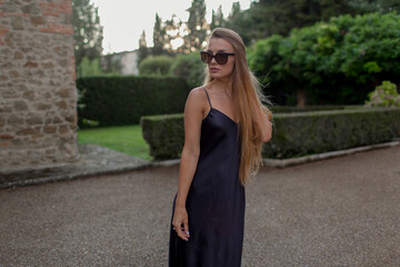 Young beautiful model in black dress and with sunglasses