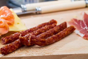 Spicy dried sausages on a meat and cheese board