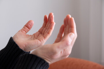 Praying hands of muslim woman at home.