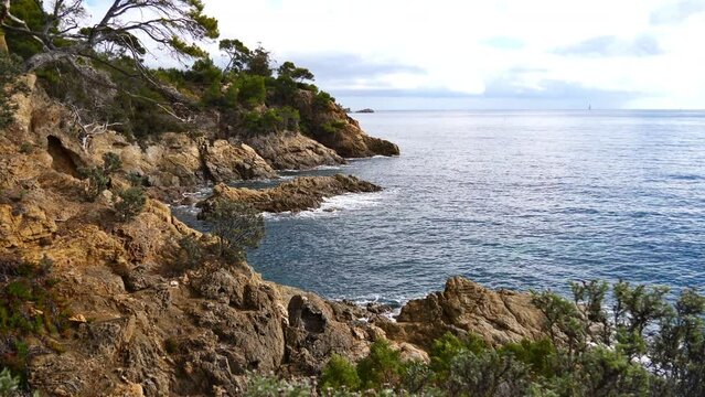 View of the mediterranean coast with rugged rocks near town Le Lavandou at the French Riviera, France at Pointe du Layet on cloudy day.