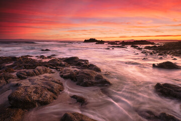 Fototapeta na wymiar Sunrise on the rocky shore of Pacific Grove overlooking Monterey Bay.