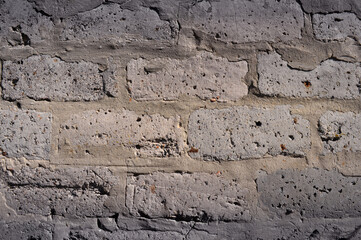 Background of a gray wall laid on a mortar of old bricks
