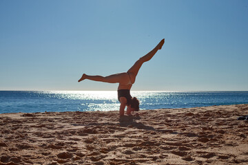 Fototapeta na wymiar A closeup of a young woman doing a yoga on the beach