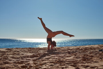 Fototapeta na wymiar A closeup of a woman doing a yoga on the beach