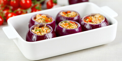 Stuffed onions recipe. Red onions stuffed with meat and vegetables in white bowl ready to bake in the oven. close up