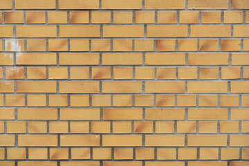 Yellow brick wall background texture. Building facade with rows of stones. Masonry pattern backdrop. Dirty weathered exterior of a house.