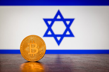 Golden physical Bitcoin with Israel flag in the background