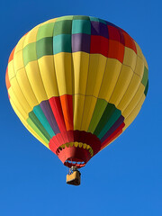 Fototapeta premium Hot Air Ballon in Many Colors Glides over Desert