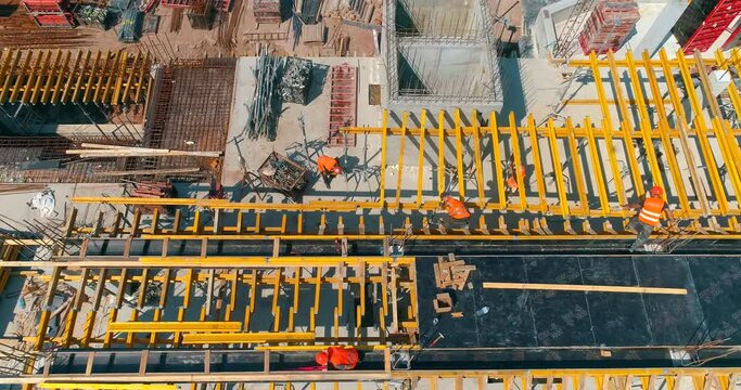 Construction process of a modern football stadium. Builders make formwork at the construction site of a new stadium. Aerial view of reinforced concrete construction